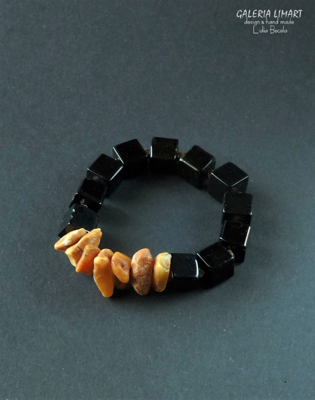 bransoletka z prawdziwego mlecznego bursztynu bałtyckiego w pięknym ciepłym słonecznym kolorze oraz bryłek czarnego onyksu w kształcie regularnych sześcianów na elastycznym nośniku