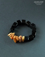 bransoletka z prawdziwego mlecznego bursztynu bałtyckiego w pięknym ciepłym słonecznym kolorze oraz bryłek czarnego onyksu w kształcie regularnych sześcianów na elastycznym nośniku
